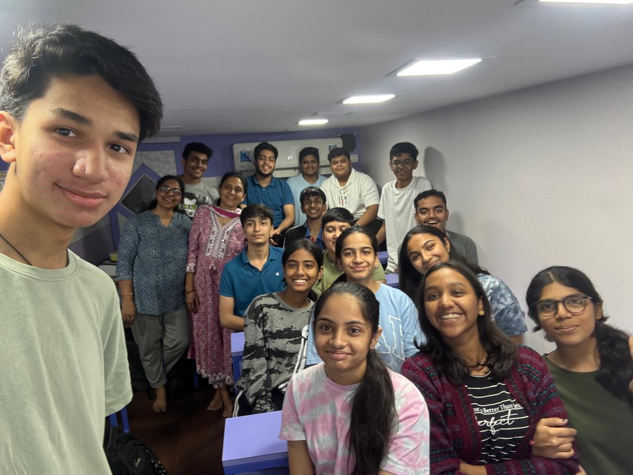 Group selfie of students with teacher inside classroom